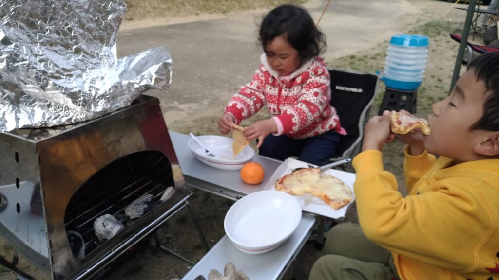 KAMADOで焼いたピザを食べている子供たち